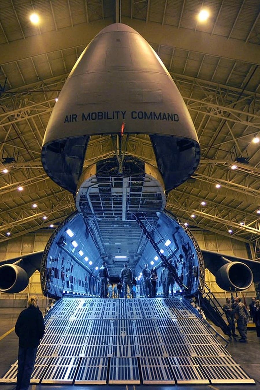 Air Mobility Command cargo aircraft with its nose door raised for loading inside a hangar — air freight operations taught at Corrivex